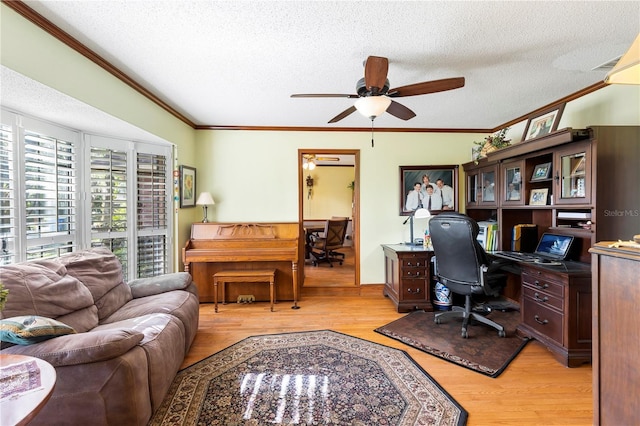 office featuring a textured ceiling, ornamental molding, a ceiling fan, and light wood-style flooring