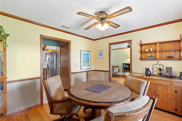 dining area featuring a ceiling fan, visible vents, and light wood finished floors