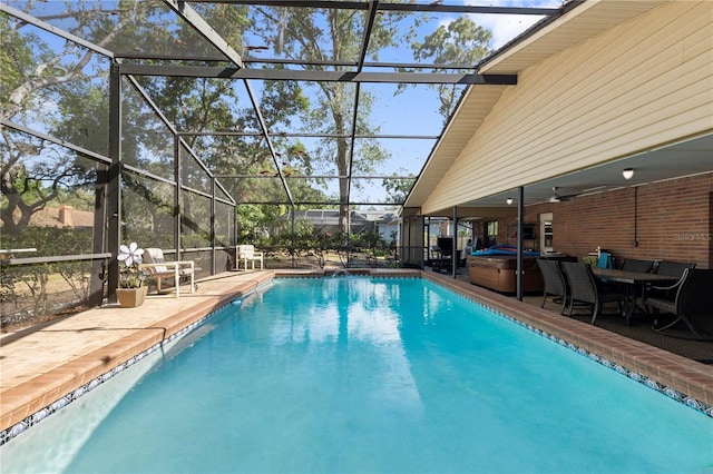 pool with a hot tub, a patio area, and glass enclosure