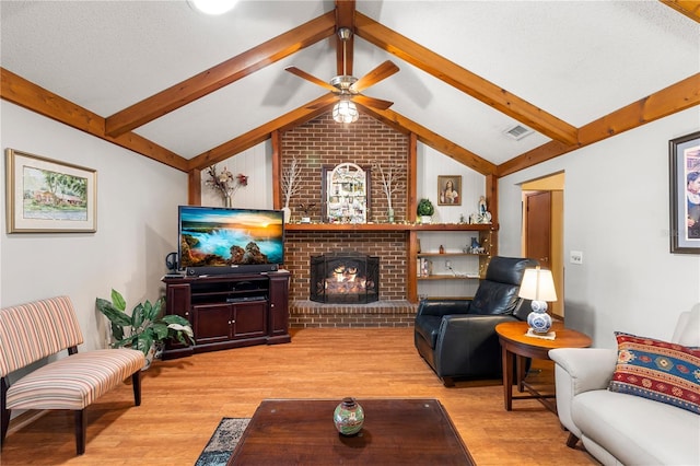 living room with visible vents, a ceiling fan, a brick fireplace, light wood-style floors, and lofted ceiling with beams