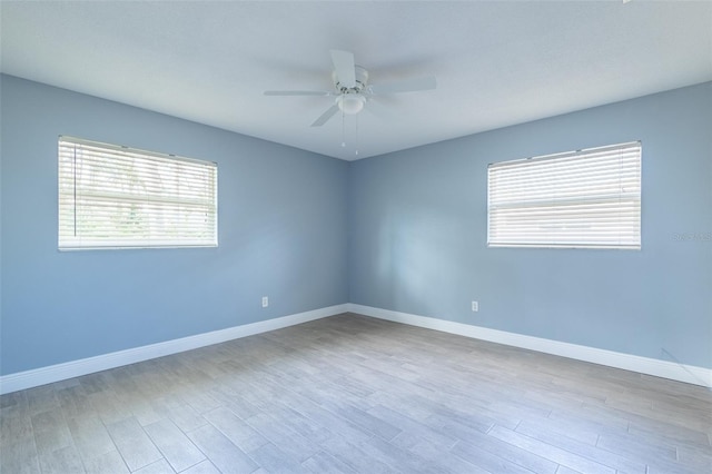 spare room with wood finished floors, baseboards, and ceiling fan