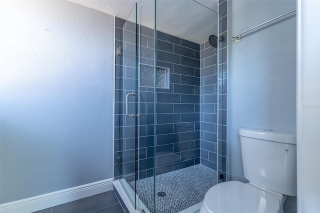 full bath featuring toilet, tile patterned floors, and a stall shower