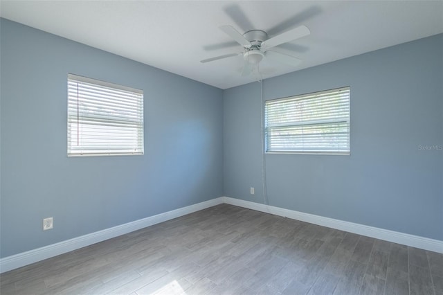 unfurnished room featuring wood finished floors, baseboards, and ceiling fan