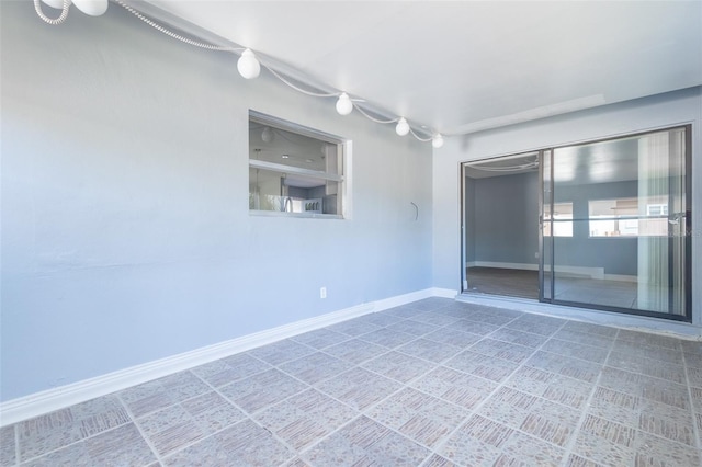 unfurnished room with baseboards
