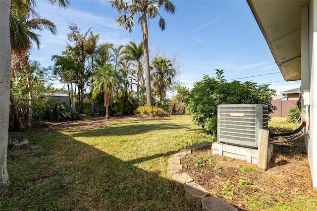 view of yard with fence and central air condition unit