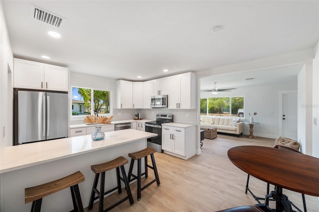 1401 49th St N, Saint Petersburg, FL 33710 - kitchen with appliances with stainless steel finishes, a breakfast bar, light countertops, healthy amount of natural light, and recessed lighting