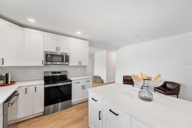 1401 49th St N, Saint Petersburg, FL 33710 - kitchen with stainless steel appliances, light wood-type flooring, light countertops, decorative backsplash, and recessed lighting