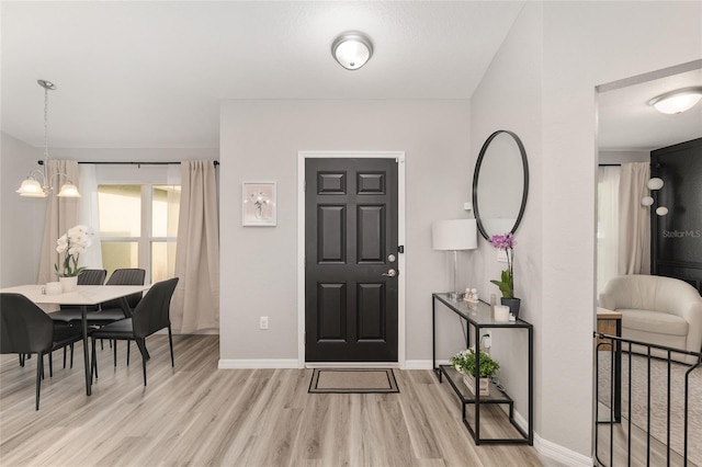 6873 SW 131st Pl, Ocala, FL 34473 - foyer entrance featuring light wood-style floors, baseboards, and a notable chandelier