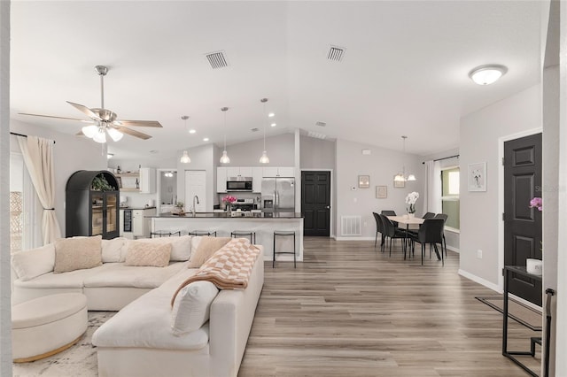 6873 SW 131st Pl, Ocala, FL 34473 - living area with a ceiling fan, vaulted ceiling, light wood finished floors, and visible vents