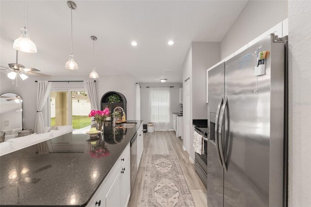 6873 SW 131st Pl, Ocala, FL 34473 - kitchen with white cabinets, appliances with stainless steel finishes, a sink, light wood-style floors, and a ceiling fan