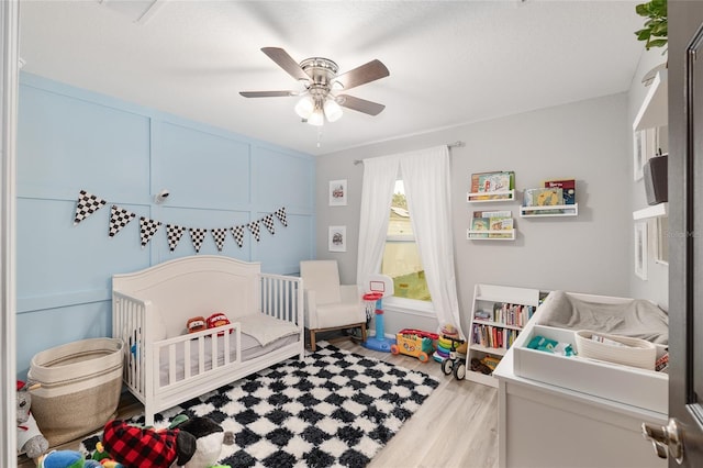 6873 SW 131st Pl, Ocala, FL 34473 - bedroom with a nursery area, a ceiling fan, and wood finished floors