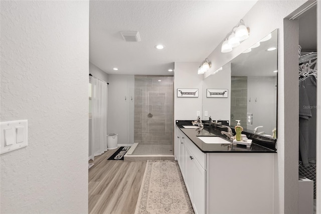 6873 SW 131st Pl, Ocala, FL 34473 - full bath with double vanity, a textured wall, wood finished floors, recessed lighting, and a shower stall