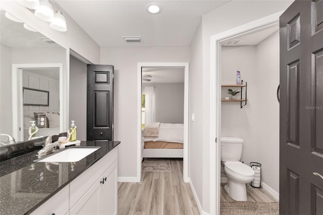6873 SW 131st Pl, Ocala, FL 34473 - ensuite bathroom featuring baseboards, connected bathroom, wood finished floors, and toilet