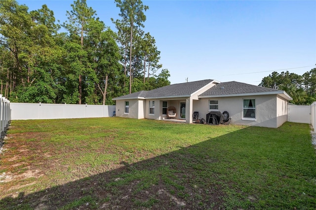 6873 SW 131st Pl, Ocala, FL 34473 - rear view of house featuring a lawn, a fenced backyard, stucco siding, and a shingled roof