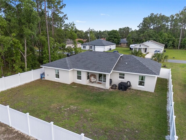 6873 SW 131st Pl, Ocala, FL 34473 - back of house with a shingled roof, stucco siding, a fenced backyard, a patio area, and a lawn