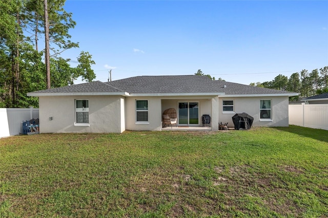 6873 SW 131st Pl, Ocala, FL 34473 - back of house featuring a yard, a fenced backyard, roof with shingles, and stucco siding