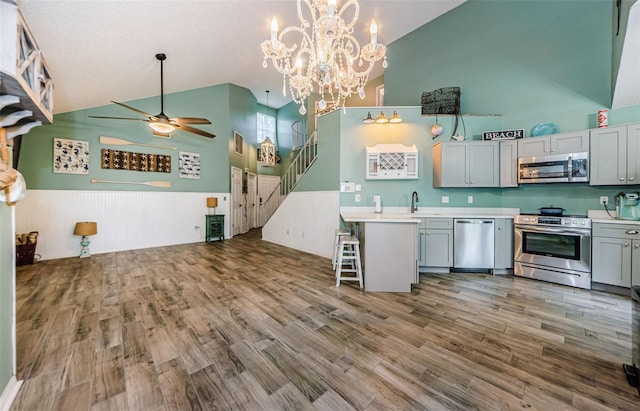 678 Greenglen Ln, Palm Harbor, FL 34684 - kitchen featuring appliances with stainless steel finishes, high vaulted ceiling, ceiling fan, wood finished floors, and light countertops