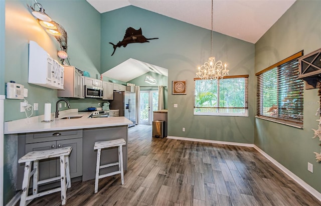 678 Greenglen Ln, Palm Harbor, FL 34684 - kitchen with stainless steel appliances, light countertops, a chandelier, dark wood-type flooring, and a peninsula