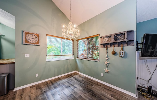678 Greenglen Ln, Palm Harbor, FL 34684 - unfurnished dining area featuring a chandelier, wood finished floors, vaulted ceiling, baseboards, and a textured ceiling