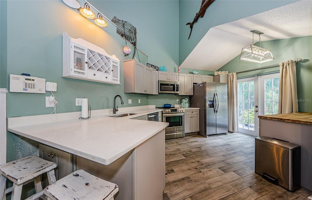 678 Greenglen Ln, Palm Harbor, FL 34684 - kitchen with appliances with stainless steel finishes, a sink, a peninsula, light countertops, and vaulted ceiling