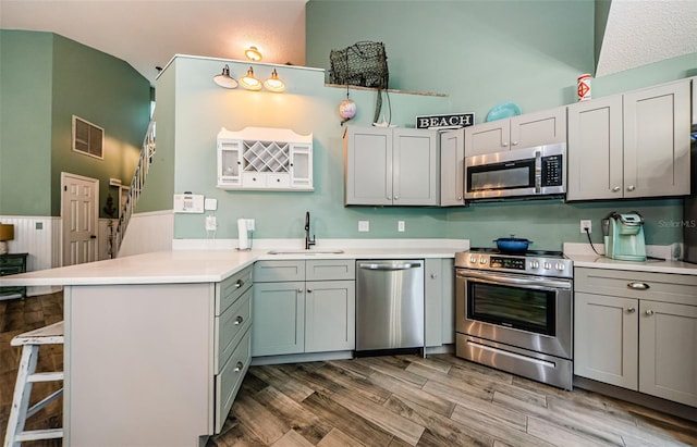 678 Greenglen Ln, Palm Harbor, FL 34684 - kitchen with appliances with stainless steel finishes, a sink, a peninsula, a kitchen breakfast bar, and light countertops
