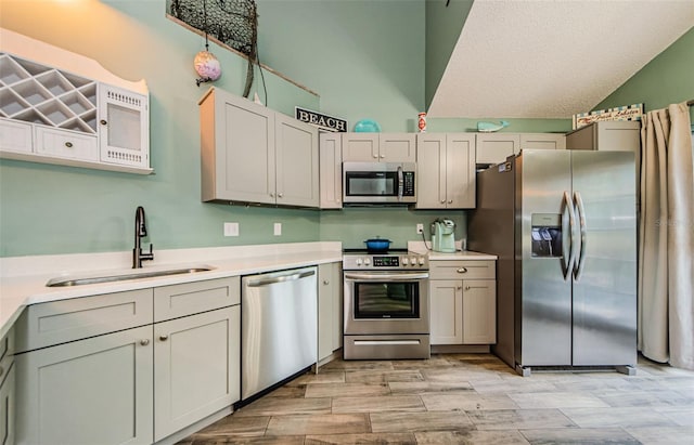 678 Greenglen Ln, Palm Harbor, FL 34684 - kitchen with appliances with stainless steel finishes, a sink, lofted ceiling, light countertops, and a textured ceiling