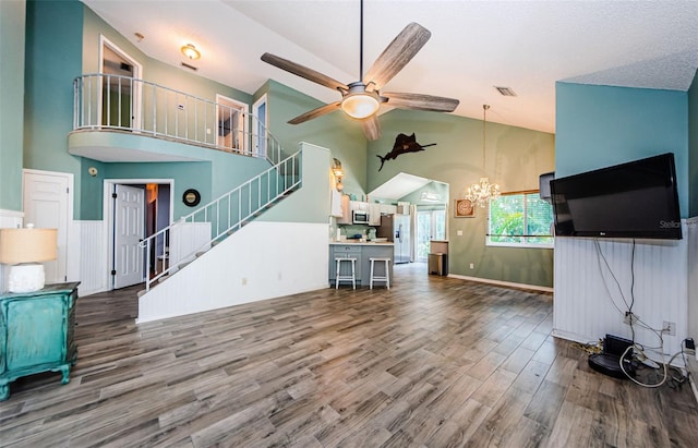 678 Greenglen Ln, Palm Harbor, FL 34684 - living area with high vaulted ceiling, a chandelier, ceiling fan, wood finished floors, and stairs