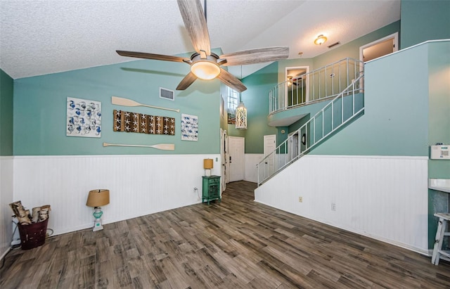 678 Greenglen Ln, Palm Harbor, FL 34684 - living room featuring vaulted ceiling, a wainscoted wall, wood finished floors, stairs, and a textured ceiling