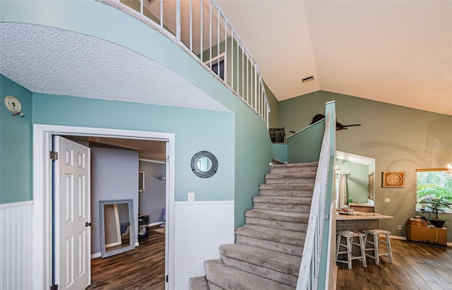678 Greenglen Ln, Palm Harbor, FL 34684 - stairs with wood finished floors, lofted ceiling, and a wainscoted wall