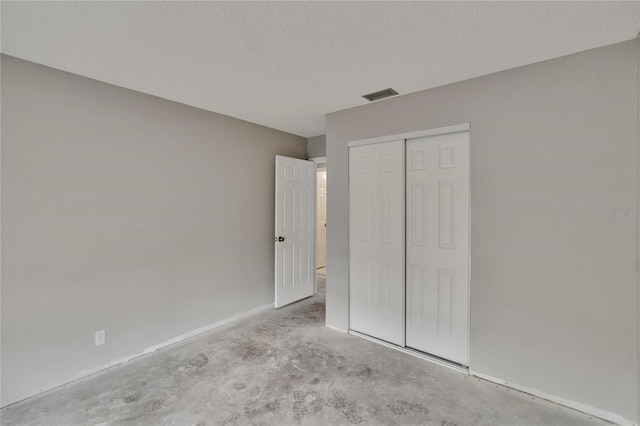 814 Seabreeze Dr, Ruskin, FL 33570 - unfurnished bedroom featuring concrete flooring, a closet, a textured ceiling, and baseboards