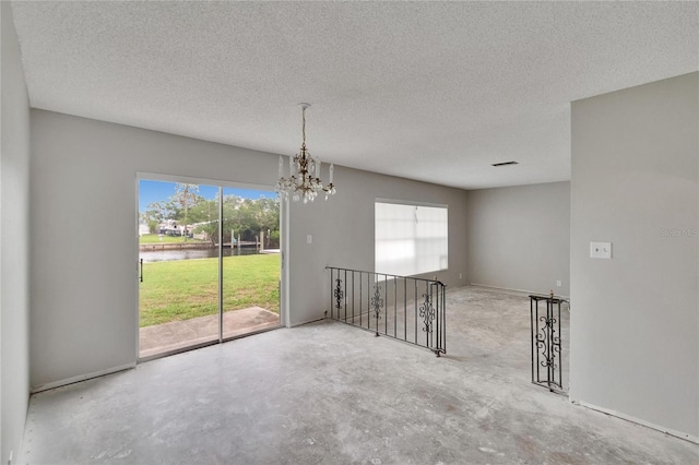 814 Seabreeze Dr, Ruskin, FL 33570 - spare room with a water view, unfinished concrete floors, a chandelier, plenty of natural light, and a textured ceiling