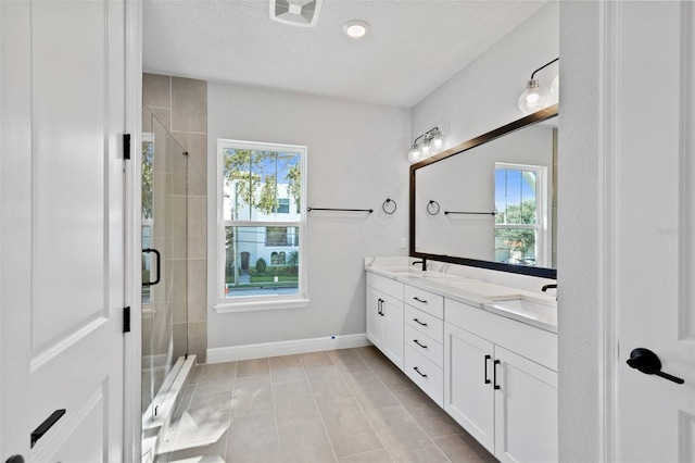 bathroom featuring healthy amount of natural light, a stall shower, and double vanity