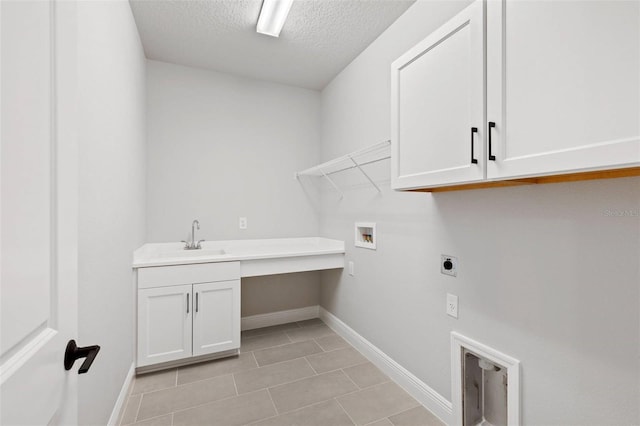laundry room with hookup for an electric dryer, cabinet space, hookup for a washing machine, a textured ceiling, and baseboards