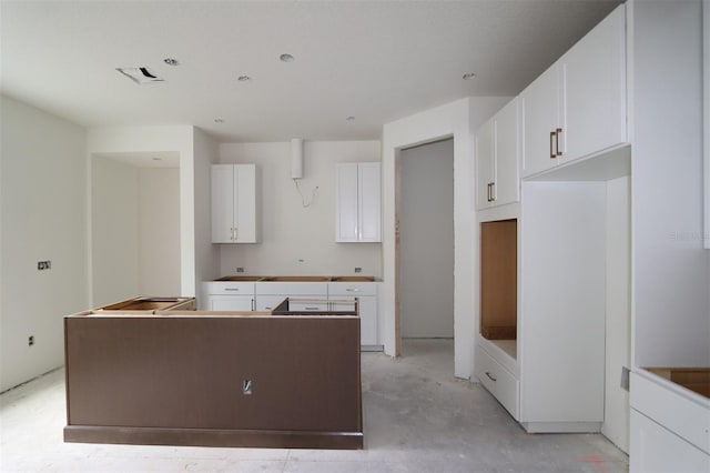 1311 S Moody Ave Unit 1, Tampa, FL 33629 - kitchen with a kitchen island, concrete floors, and white cabinets