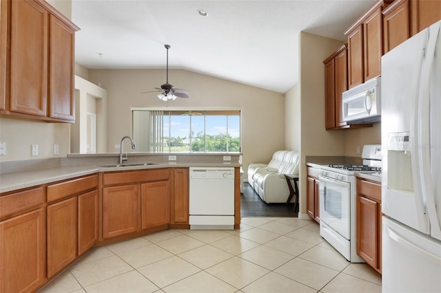 kitchen featuring white appliances, a sink, lofted ceiling, ceiling fan, and brown cabinets