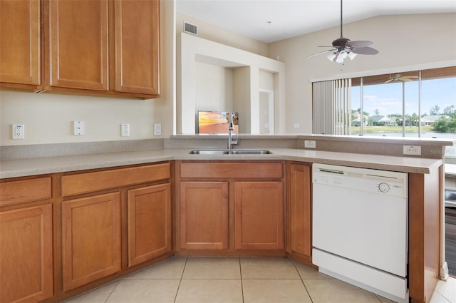 kitchen featuring dishwasher, a sink, brown cabinetry, light tile patterned flooring, and lofted ceiling