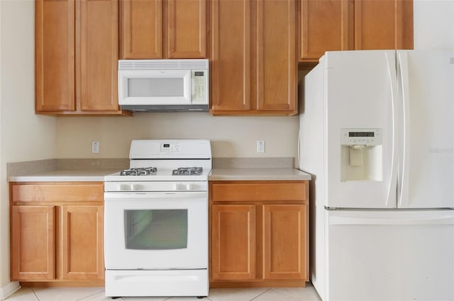 kitchen featuring white appliances, light countertops, and light tile patterned floors