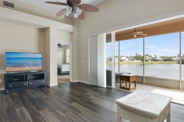living room featuring ceiling fan, healthy amount of natural light, and a water view