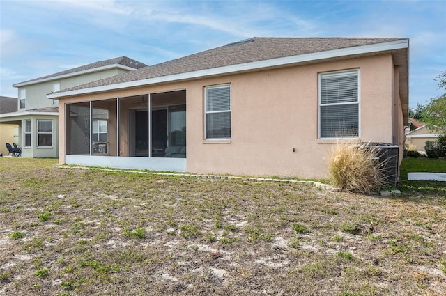 back of property featuring a sunroom, stucco siding, and roof with shingles