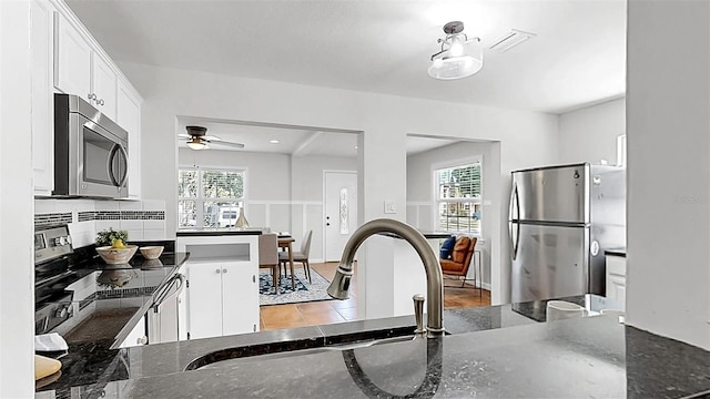 1402 Freemont St S, Gulfport, FL 33707 - kitchen featuring appliances with stainless steel finishes, ceiling fan, white cabinetry, a sink, and dark stone counters