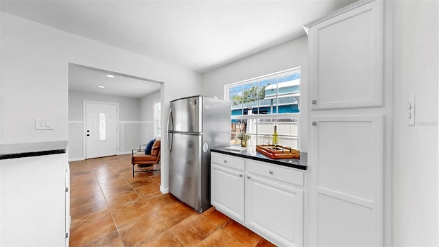 1402 Freemont St S, Gulfport, FL 33707 - kitchen with freestanding refrigerator, white cabinetry, light tile patterned floors, and dark countertops
