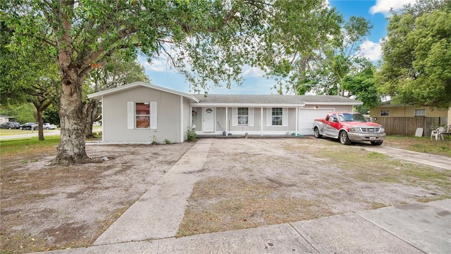 995 Merrimac St, Deltona, FL 32725 - ranch-style home with fence, a porch, an attached garage, and driveway