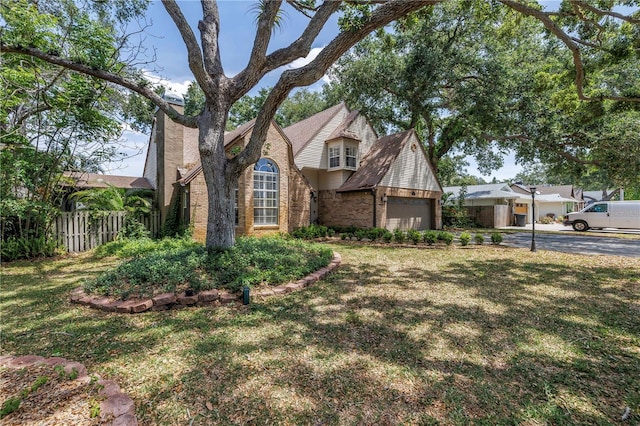13785 Oak Forest Blvd S, Seminole, FL 33776 - english style home with brick siding, an attached garage, fence, and a front yard