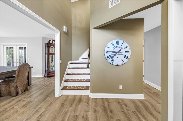 13785 Oak Forest Blvd S, Seminole, FL 33776 - staircase with baseboards, visible vents, french doors, and wood finished floors