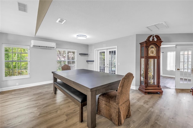 13785 Oak Forest Blvd S, Seminole, FL 33776 - dining room with a wall unit AC, french doors, wood finished floors, and visible vents