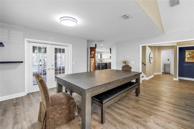 13785 Oak Forest Blvd S, Seminole, FL 33776 - dining space with visible vents, baseboards, wood finished floors, and french doors