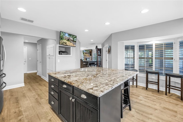 13785 Oak Forest Blvd S, Seminole, FL 33776 - kitchen with light wood-style floors, dark cabinets, baseboards, and visible vents