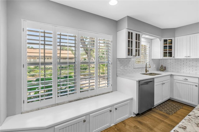 13785 Oak Forest Blvd S, Seminole, FL 33776 - kitchen with decorative backsplash, dark wood-type flooring, white cabinets, a sink, and dishwasher