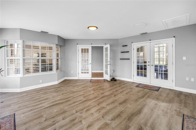 13785 Oak Forest Blvd S, Seminole, FL 33776 - unfurnished living room featuring french doors, baseboards, and wood finished floors