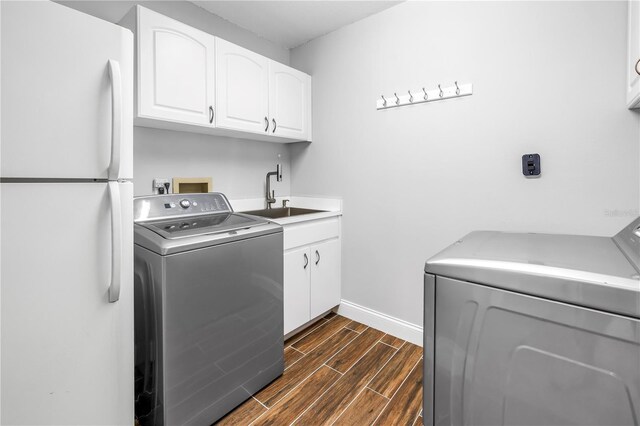13785 Oak Forest Blvd S, Seminole, FL 33776 - clothes washing area featuring baseboards, wood finish floors, a sink, and washer hookup